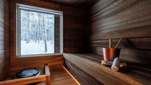 A wooden cabin interior with a bench, a window, and a metal bucket. - Skýra Retreat (Rovaniemi)