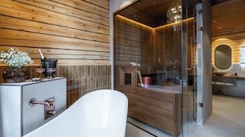A modern bathroom with a freestanding bathtub, wooden paneling, and a glass-enclosed shower area.