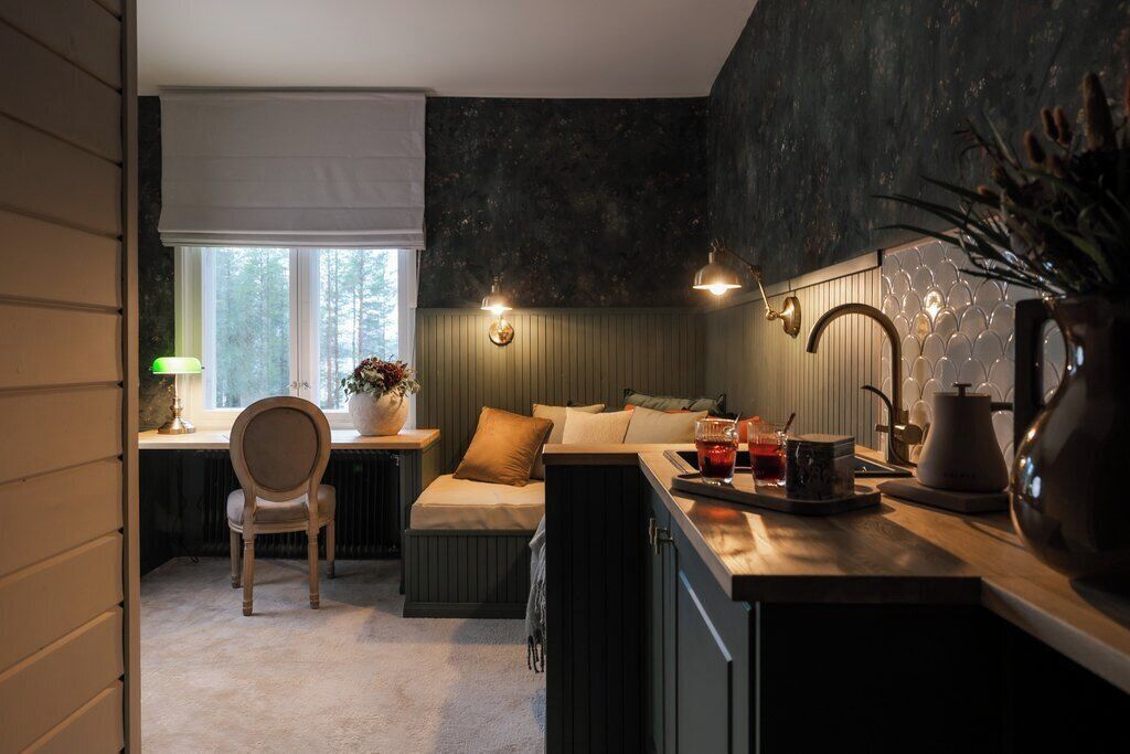 A cozy kitchen with a dining area, a window with a view, and a bar area with a kettle and glasses.