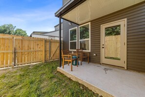 A covered outdoor area with a concrete floor, wooden chairs, and a door. - 7 Bedrooms 6 Baths and more! (Lafayette)