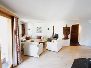 A spacious living room with a sofa set, a coffee table, and a wooden floor. - Apartment Tauschna mit Privat-Pool by Interhome (Samedan)