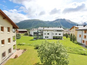 Un quartier résidentiel avec des immeubles modernes, une pelouse bien entretenue et une chaîne de montagnes en arrière-plan.