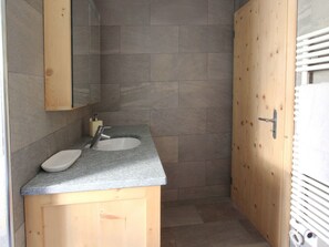 A bathroom with a wooden vanity, two sinks, and a mirror. - Apartment Diala by Interhome (Zuoz)