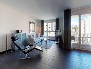 A modern living room with a sofa, a glass coffee table, and a black lounge chair. - Apartment Braschunauns 10 by Interhome (St. Moritz)