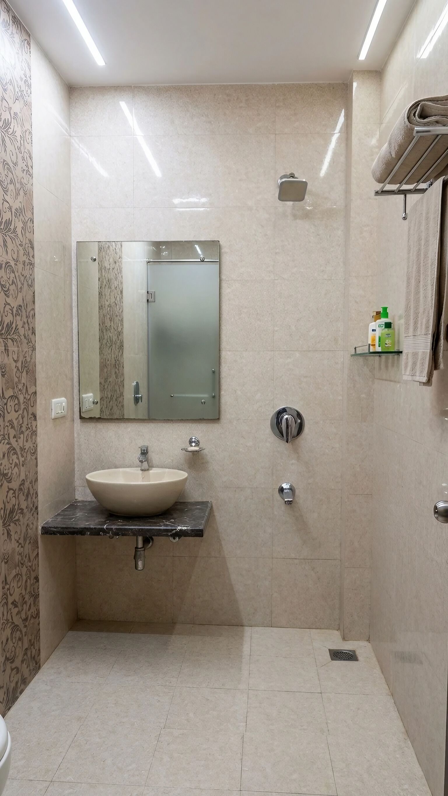 Un baño moderno con un espejo grande, un lavamanos, una ducha y un perchero para toallas.