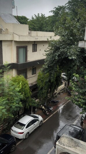 Un carrer residencial amb cotxes aparcats i un cotxe blanc al primer pla.