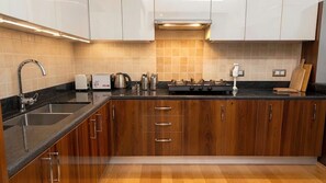 Una cocina moderna con pileta, estufa y alacenas de madera.