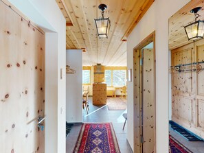 A wooden interior with a high ceiling, a central column, and a view through a window. - Apartment Chalcherin 4 by Interhome (Celerina)