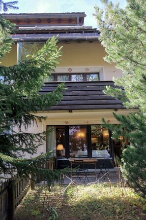 A building with a traditional architectural style, featuring a wooden balcony and a glass entrance. - Apartment Muntagna Alva EG by Interhome (St. Moritz)