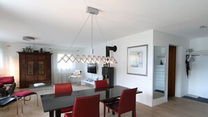 Ein modernes Wohnzimmer mit Essbereich, Kamin und großem Spiegel.