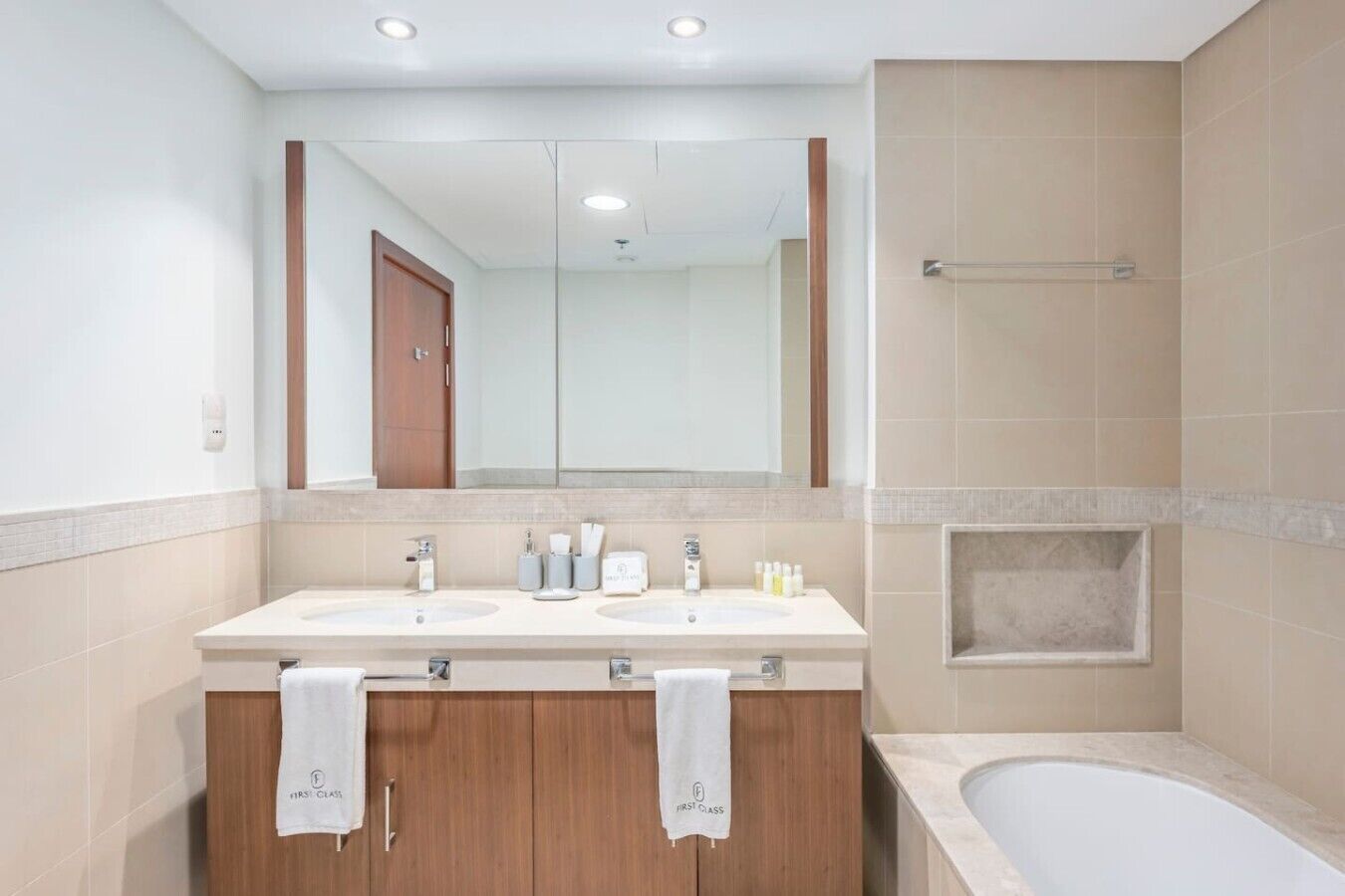 Une salle de bain avec deux lavabos, un miroir, une douche et une baignoire.