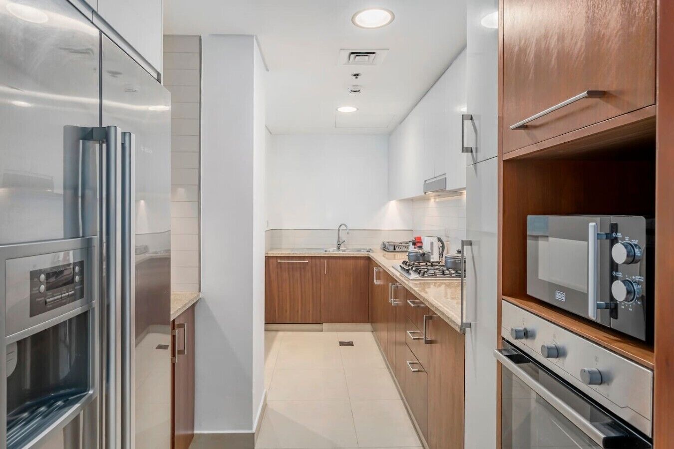 Una cocina moderna con electrodomésticos de acero inoxidable, armarios de madera y una isla central.