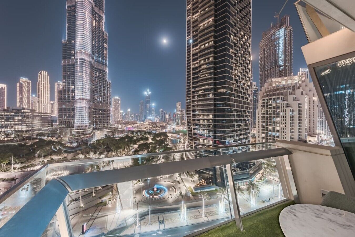 Un immeuble de grande hauteur au design moderne, entouré d’autres bâtiments imposants dans un paysage urbain.
