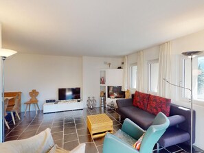 En stue med sofa, fjernsyn og sofabord.