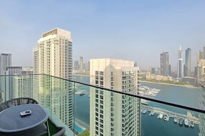 A high-rise building with a view of a marina and other buildings. - FIRST CLASS |1BR| Beachfront with Ain Dubai Views (Dubai Harbour)