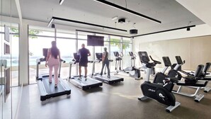 Ett modernt gym med löpband, crosstrainers och styrketräningsutrustning.