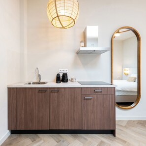 Een moderne badkamer met een houten wastafelmeubel, een wastafel, een spiegel en een hangende lamp.