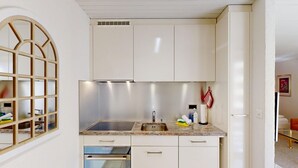 Cozinha com forno embutido, pia e janela com design de grade.
