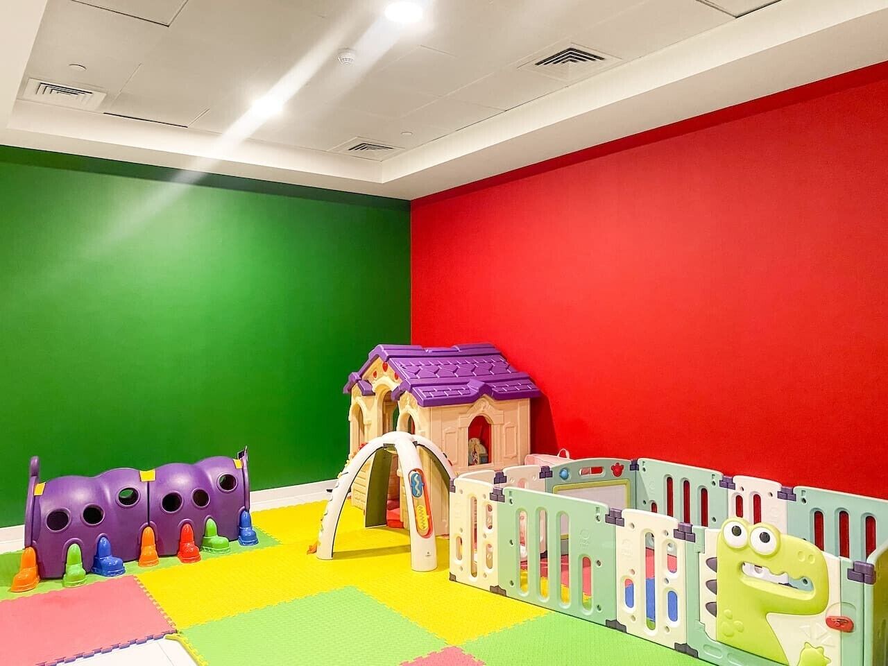 A play area with colorful toys and a small house structure.
