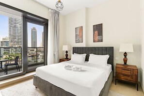 A hotel room with a large bed, two bedside tables, a view of the city, and artwork on the wall. - FIRST CLASS | 2BR | Sophisticated Marina Living (Marina)