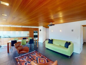 A modern living room with a green sofa, brown leather chairs, and a patterned rug. - Apartment Quadratscha by Interhome (Samedan)
