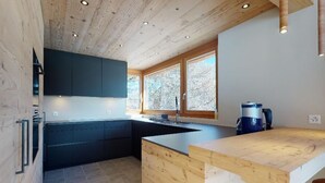 Una cocina moderna con muebles de madera, una isla central y un amplio ventanal que proporciona luz natural.