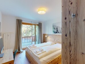 Ein Schlafzimmer mit einem Bett, einem Schreibtisch und einem Fenster mit Vorhängen.