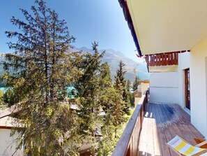 A balcony with a wooden deck overlooking a mountainous landscape. - Apartment Sungold by Interhome (St. Moritz)
