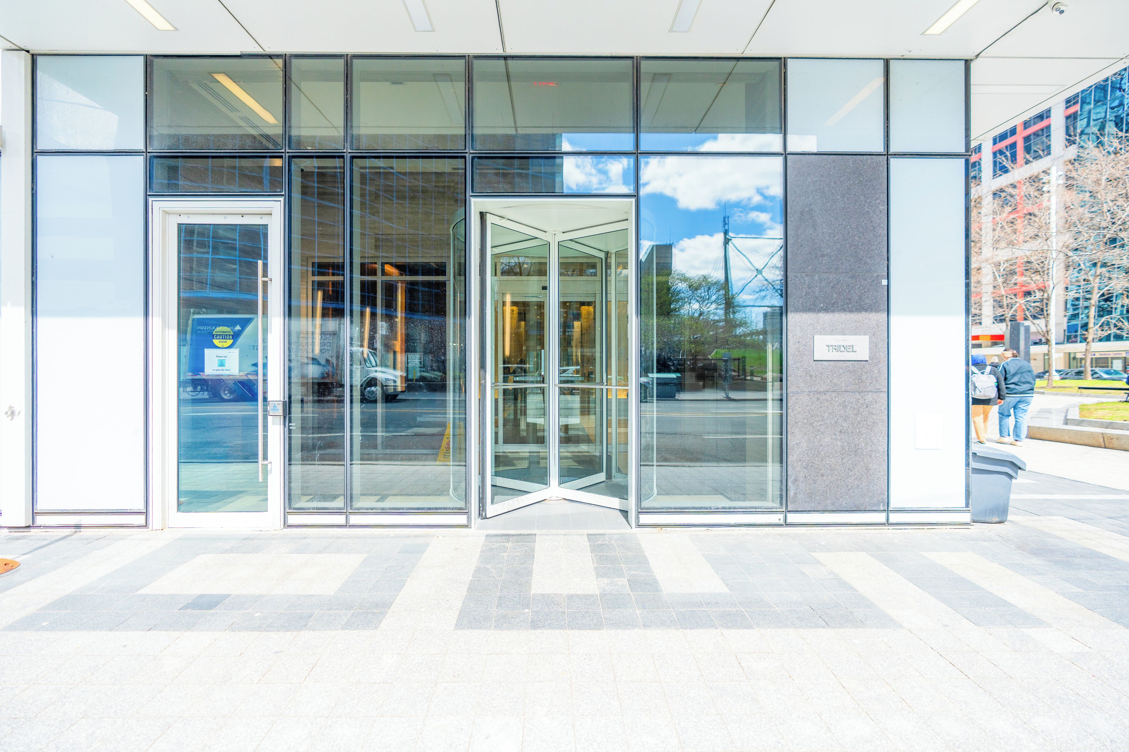 A modern building entrance with automatic sliding doors and a glass facade.
