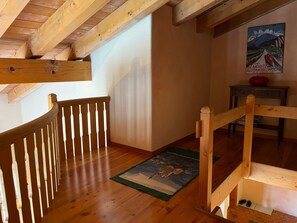 A wooden staircase with a handrail leading to a landing. - Apartment La Dmura by Interhome (Samedan)