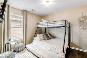 A bunk bed room with a desk and chair, a dreamcatcher, and a window with curtains. - Charming, immaculate coastal home with furnished porches, AC, & washer/dryer (Port Wentworth)