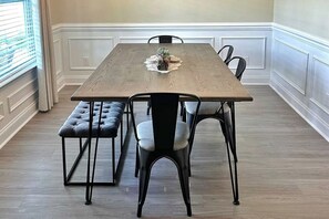 En matplats med ett träbord, fyra stolar och en bänk.