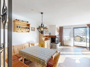 Ein Zimmer mit einem Bett, einem Holzschrank, einem Fernseher und einem großen Fenster mit Bergblick.