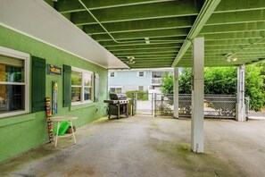 Ein Patio im Freien mit Grill, einem kleinen Tisch und einem Stuhl.