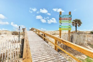 A wooden boardwalk leading to a beach with a sign listing beach rules. - Quaint 2nd-floor studio 1 block from the beach with fast WiFi, deck, cable, & AC (Tybee Island)