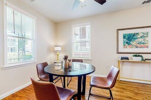 A dining area with a round table, four chairs, a lamp, and a painting on the wall. - Renovated bungalow with central AC, W/D, & modern kitchen, Free Wifi (Savannah)