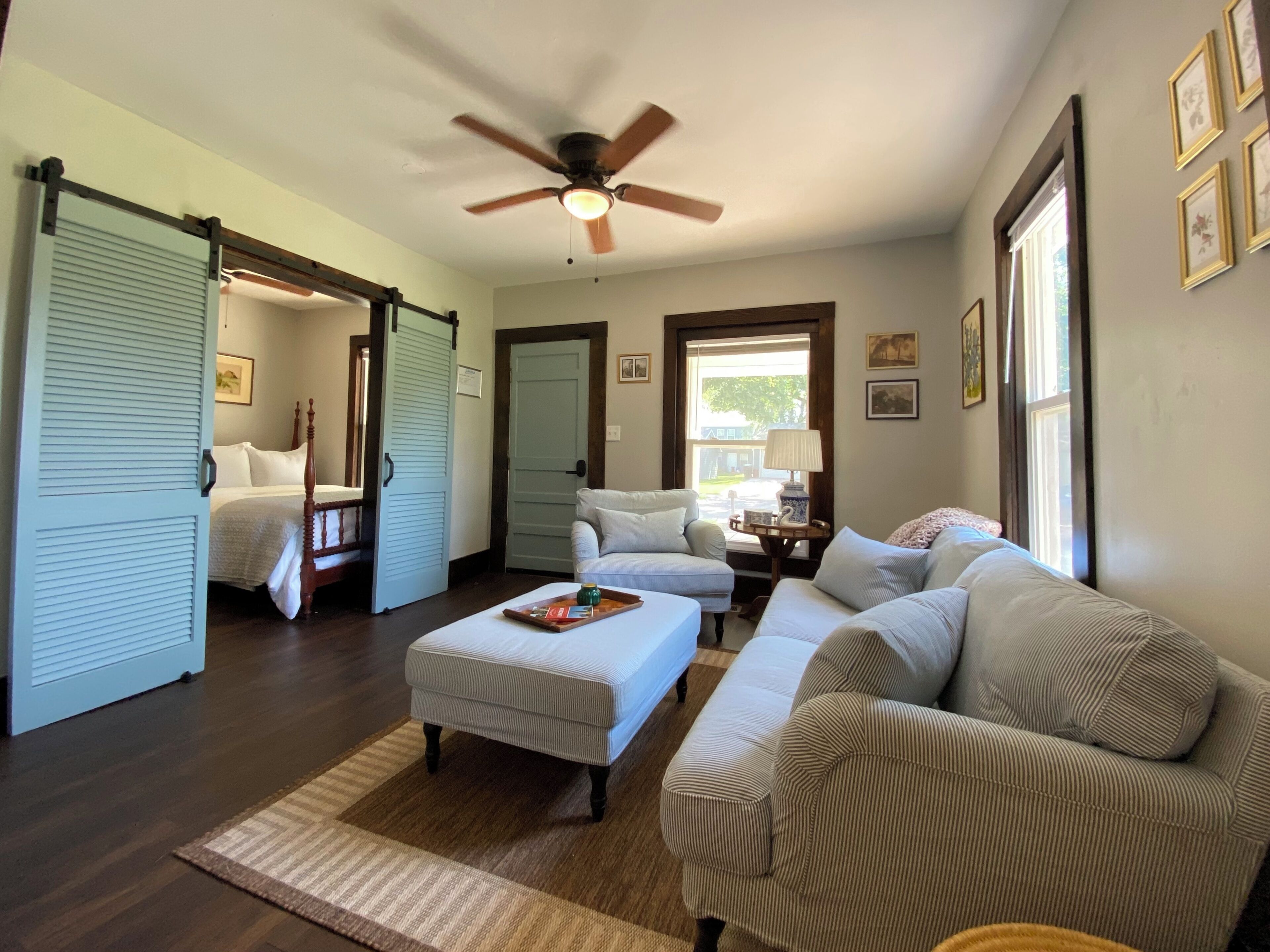 A spacious living room with a large sectional sofa, a wooden coffee table, and a ceiling fan.