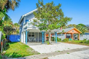 A two-story house with a covered porch and a small attached structure. - Pleasant beach home with central AC, deck & work space - walk to beach & dining (Tybee Island)