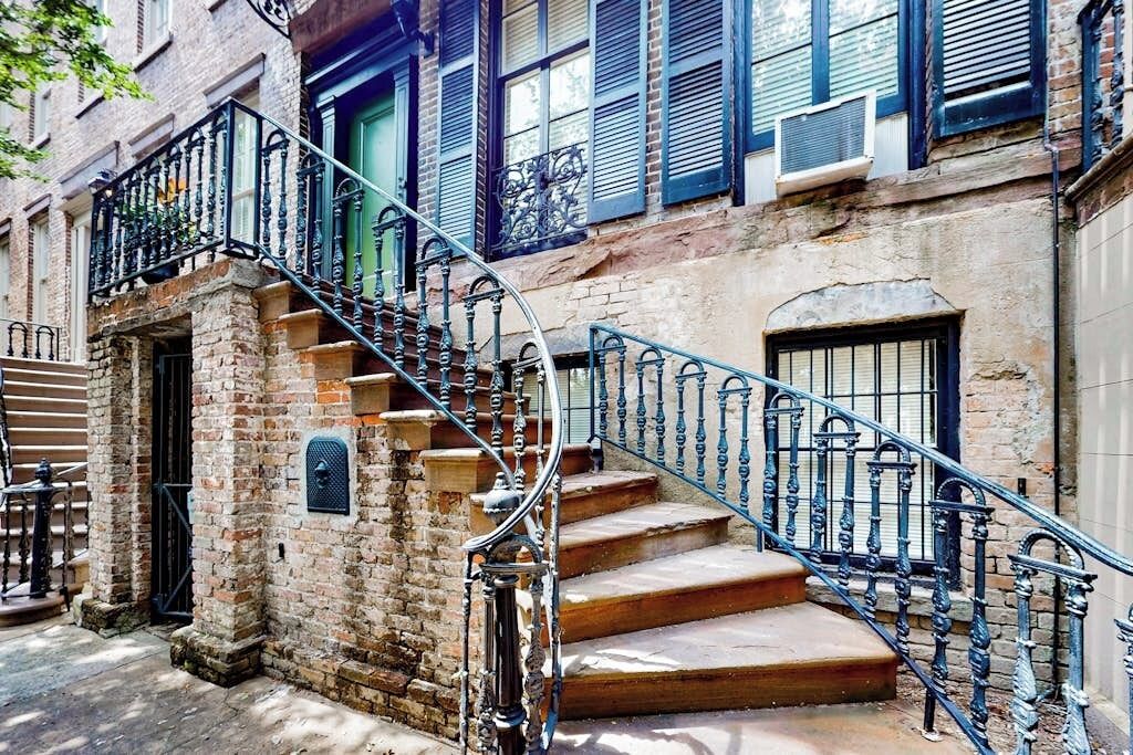 A brick building with a spiral staircase leading to a second-floor landing.