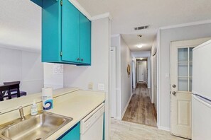 A kitchen with a sink, a countertop, and a teal cabinet. - Well-appointed home with spacious backyard, firepit, streaming, & central AC (Savannah)