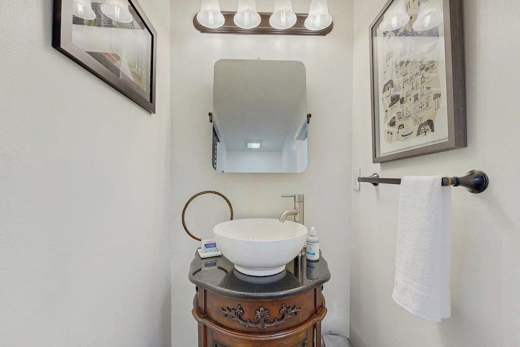 A bathroom with a white sink, a mirror, and a towel rack.