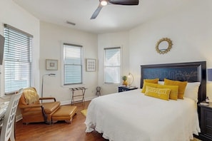 A bedroom with a bed, a chair, a desk, and a ceiling fan. - Charming Victorian home with modern comforts & steps from parks (Savannah)
