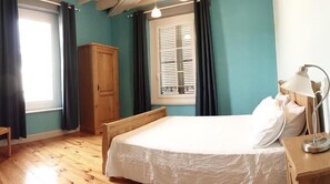 A room with a bed, wooden wardrobe, and a window with curtains. - La Distillerie 1881 (AILLEVILLERS-ET-LYAUMONT)