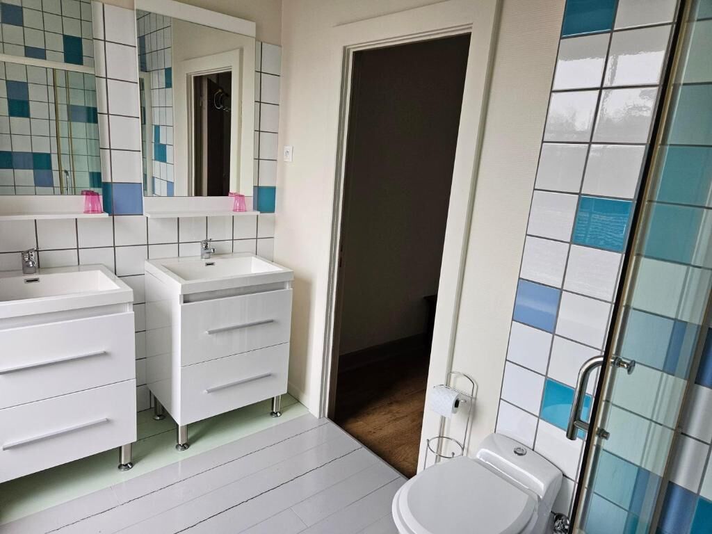A bathroom with a white sink, a mirror, and a toilet.