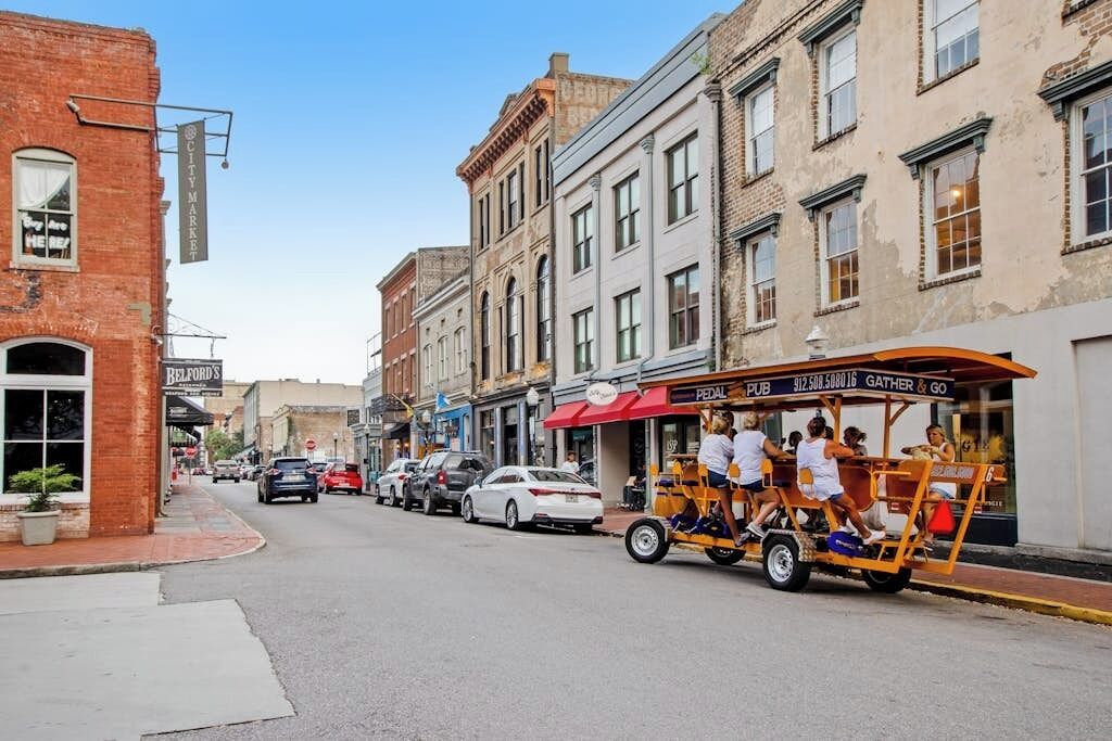 A street with buildings, a pedestrian cart, and parked cars.