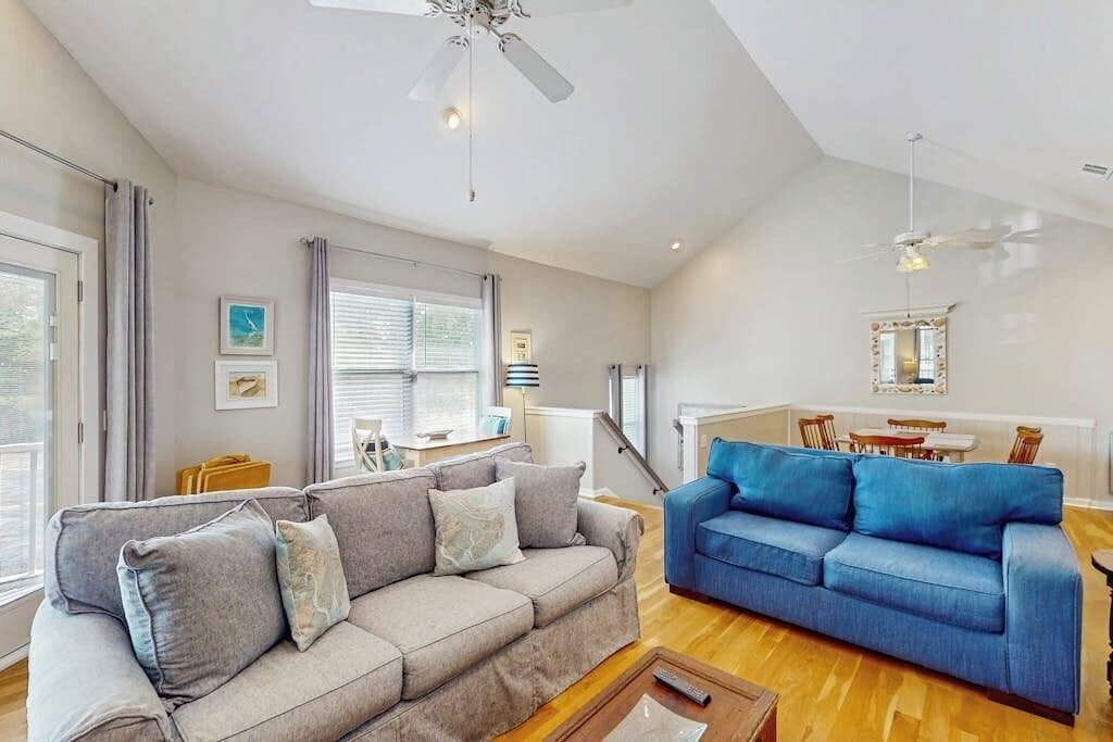 A living room with a grey sofa, a blue sofa, and a wooden coffee table.