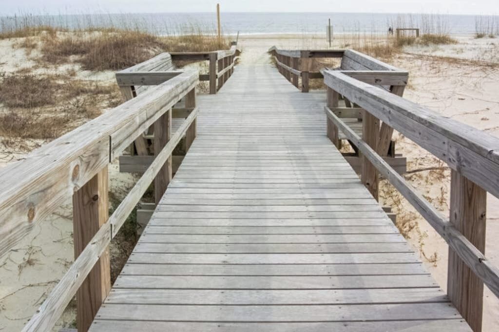 Une promenade en bois menant à une plage.