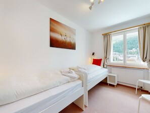A single-bed room with a window, a radiator, and a small table. - Apartment Ova Cotschna 301 by Interhome (St. Moritz)