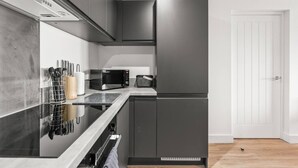 A modern kitchen with a built-in microwave, a toaster, and a stainless steel refrigerator. - Central Liverpool 2 Bedroom Apartment, Large, Modern, WIFI, Sleeps 4 (Liverpool)