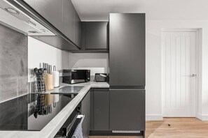 Eine moderne Küche mit Einbau-Mikrowelle, Toaster und Edelstahl-Kühlschrank.